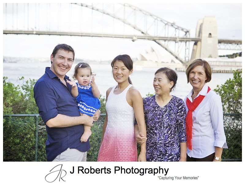 Baby girl with her parents and grandmothers and sydney harbour in the background - sydney family portrait photography